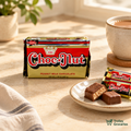 King Choc Nut peanut milk chocolate in its original black and gold package styled with chocolate bites and a cup of tea.
