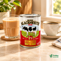 Black & White Full Cream Evaporated Milk 410g can styled beside milk tea and coffee.