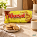 Hansel Mocha Sandwich cream-filled biscuits in the original yellow package, styled with coffee and biscuits on a warm kitchen counter.